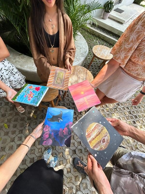 Guests holding up their finished canvases