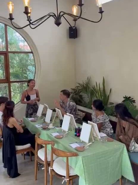 Guests painting canvases at a long table