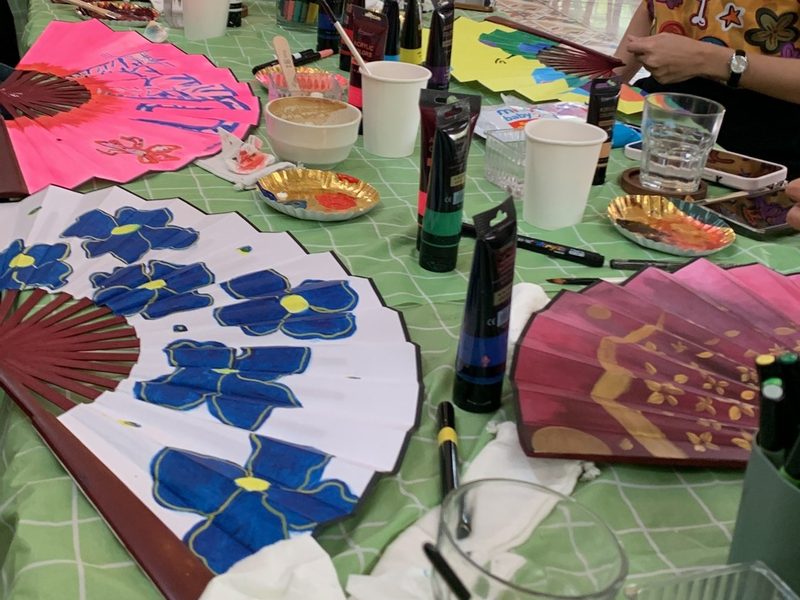 Painted fans with blue flowers on the table