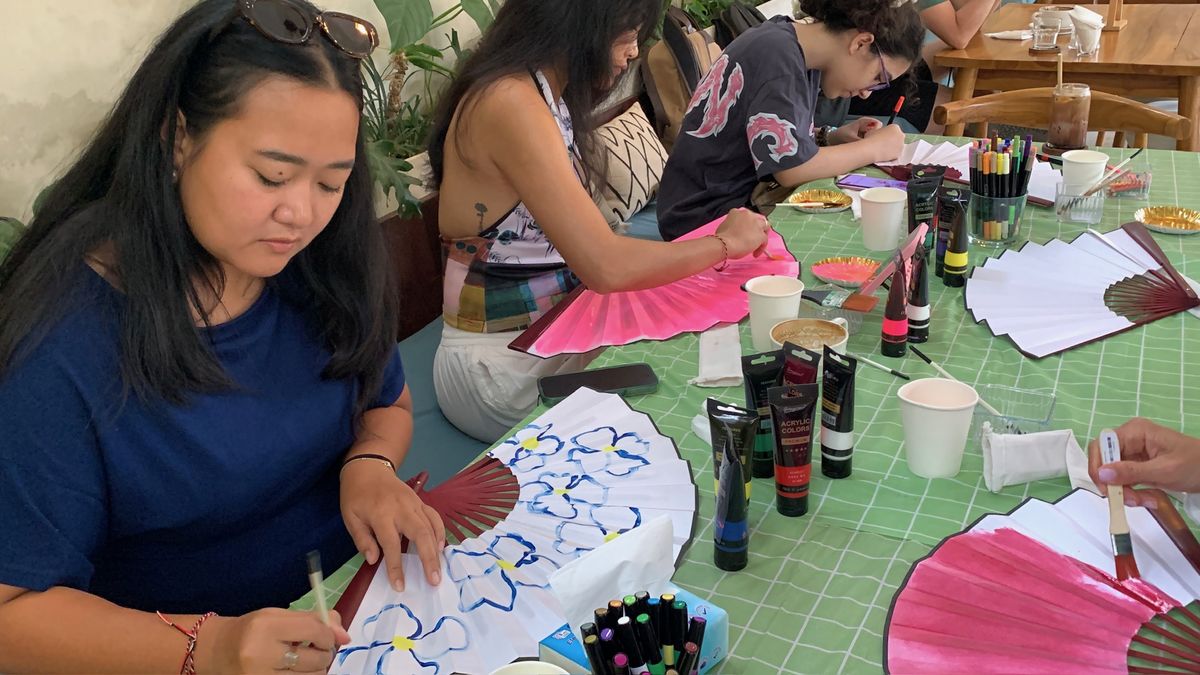 Guests painting fans around a long table