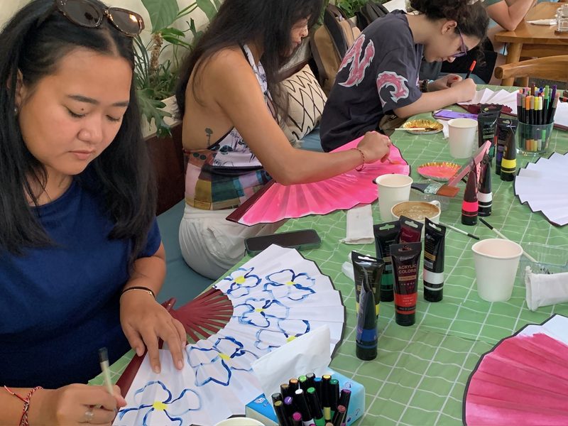 Guests painting fans around a long table