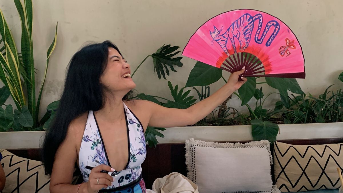 Guest laughing and holding up her finished pink fan
