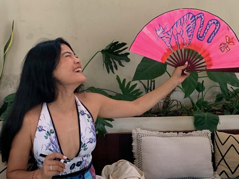 Guest laughing and holding up her finished pink fan
